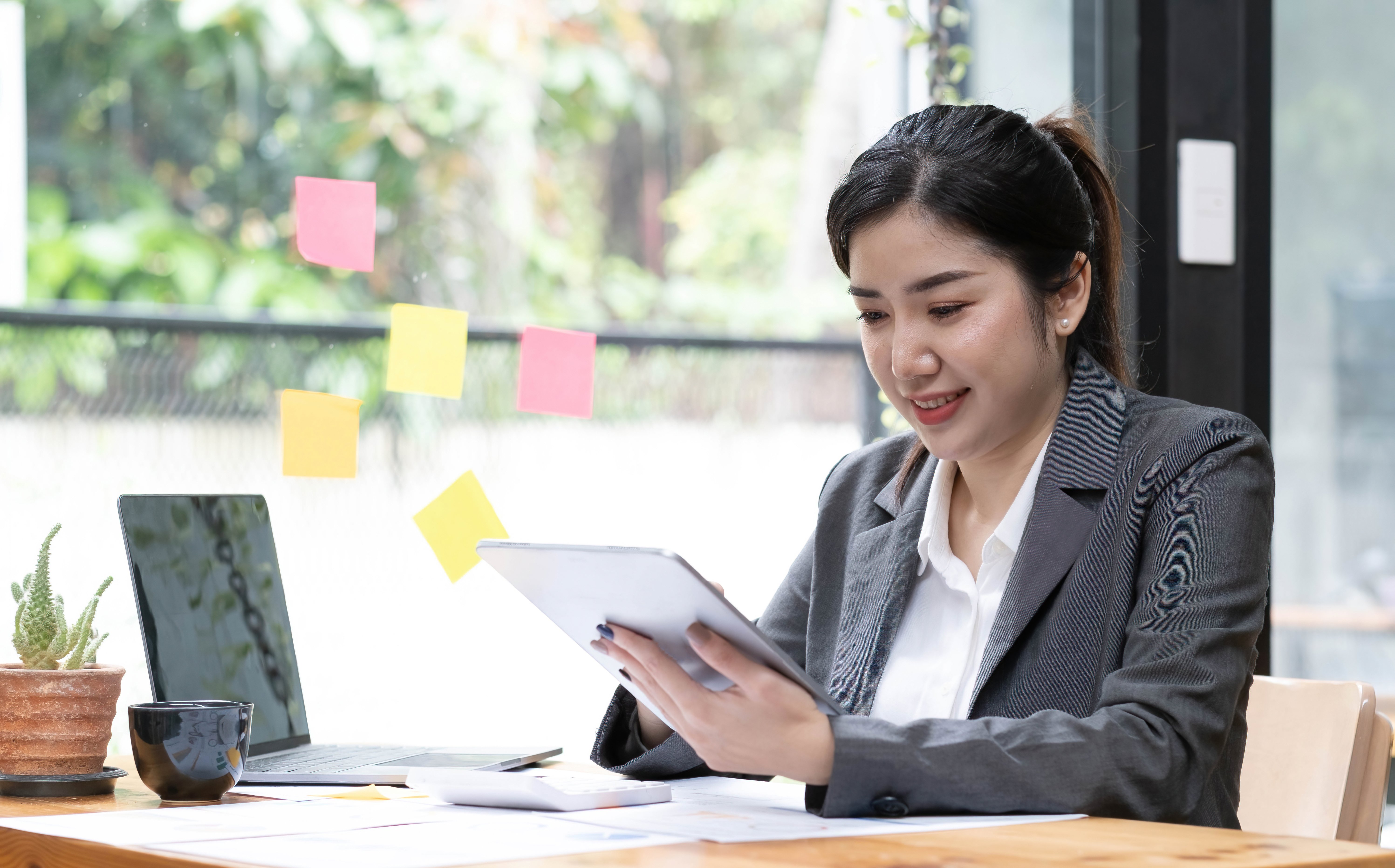 vecteezy_charming-asian-woman-working-on-a-laptop-and-tablet-at-the_11271716