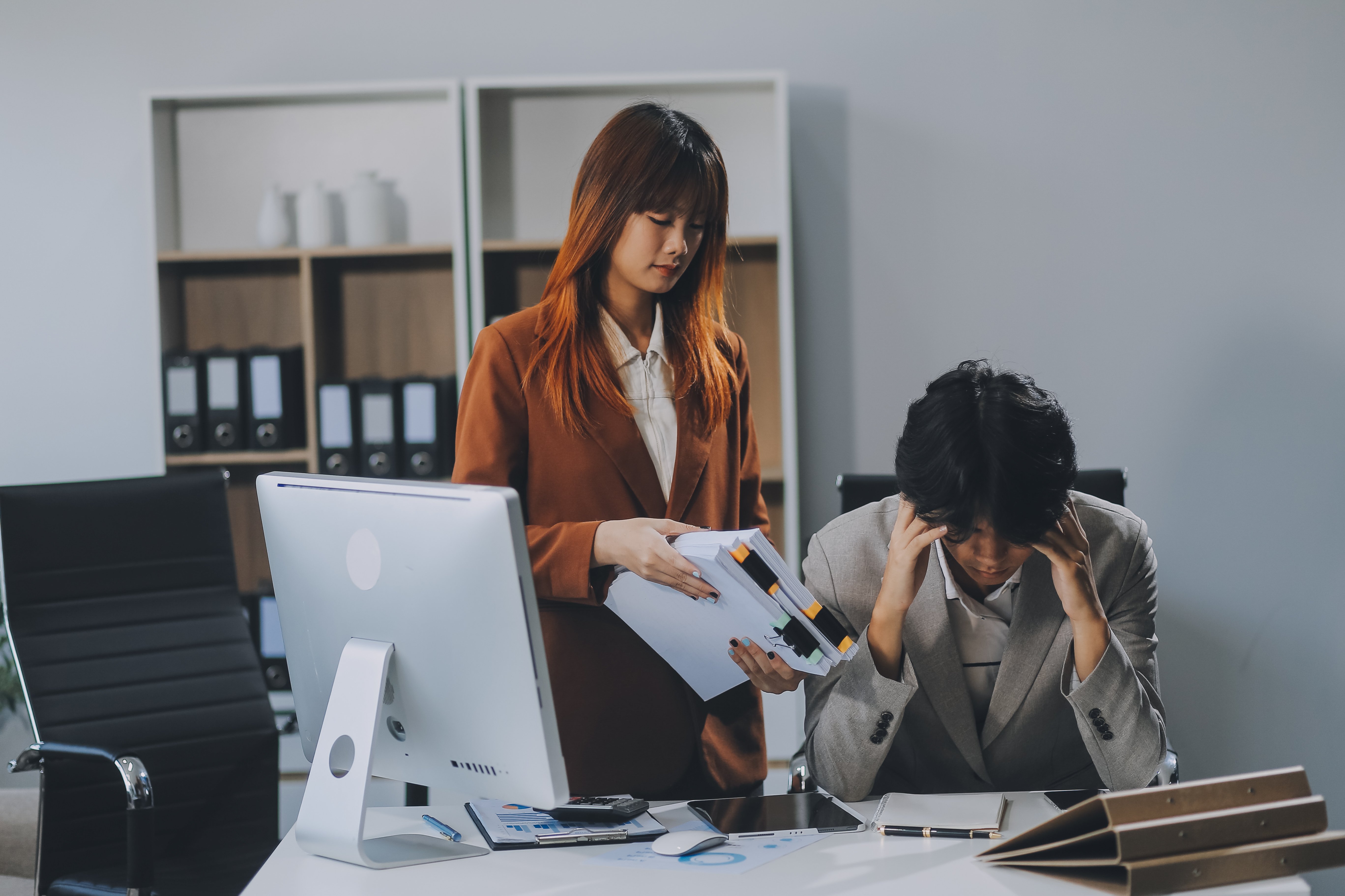 vecteezy_stressed-business-couple-working-at-big-cabinet-frustrated_49308286