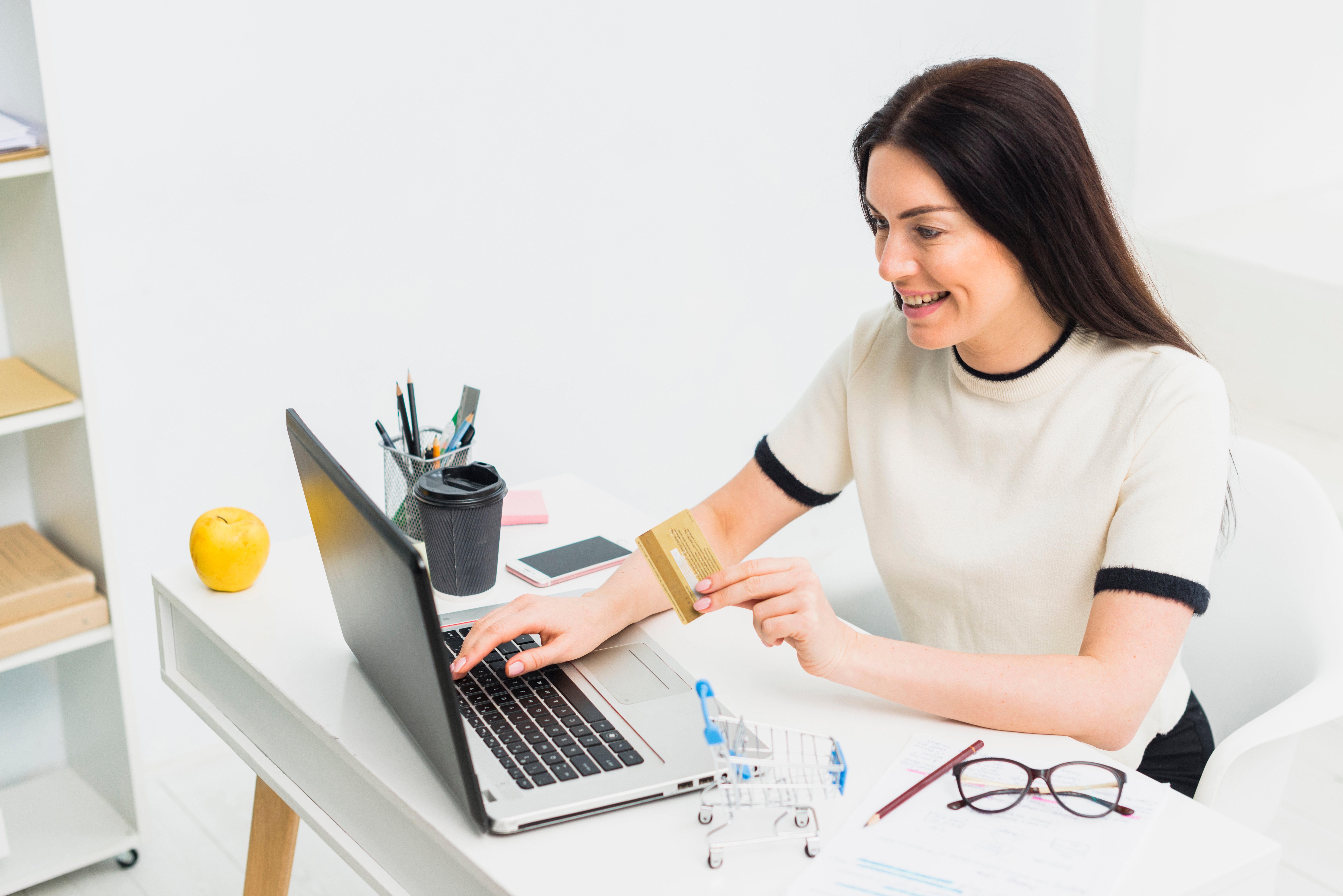 young-woman-sitting-with-credit-card-table-with-laptop
